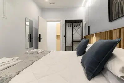 a large white bed with blue pillows in a bedroom at Arte di Roma - Guest House in Rome