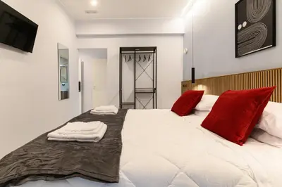 a bedroom with a large white bed with red pillows at Arte di Roma - Guest House in Rome