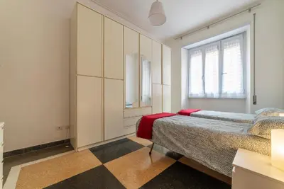 a bedroom with a bed and a large window at GuestHost - Piazza Bologna Apartment in Rome