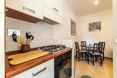 a kitchen with a stove and a table with chairs at GuestHost - Piazza Bologna Apartment in Rome