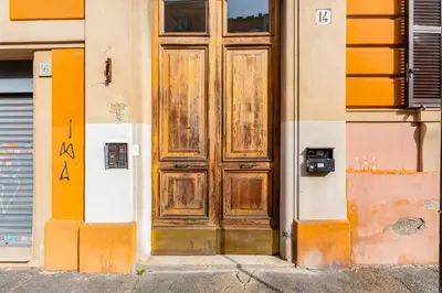 a wooden door on the side of a building at 3-Bedroom Home Near Trastevere Station in Rome