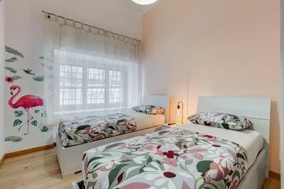 a bedroom with two beds and a flamingo mural at 3-Bedroom Home Near Trastevere Station in Rome