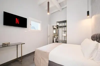 a bedroom with a bed and a tv on the wall at Domus Matris Guest House in Rome