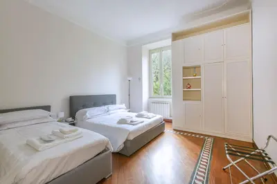 a bedroom with two beds and a large window at Family Stay in Trastevere in Rome