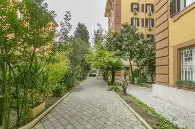 a walkway between two buildings with trees at Family Stay in Trastevere in Rome