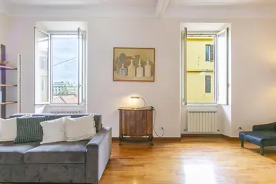 a living room with a couch and two windows at Family Stay in Trastevere in Rome
