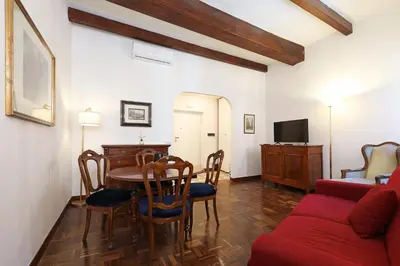 a living room with a table and a red couch at Trastevere Essence by Nosdom Properties in Rome
