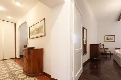 a hallway with white walls and a room with a bed at Trastevere Essence by Nosdom Properties in Rome