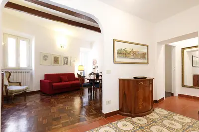 a living room with a red couch and a table at Trastevere Essence by Nosdom Properties in Rome