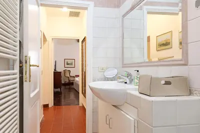 a white bathroom with a sink and a mirror at Trastevere Essence by Nosdom Properties in Rome