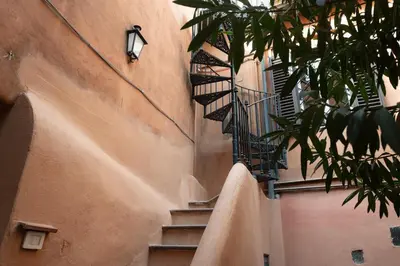 a stone building with stairs next to a building at Trastevere Rooftop Terrace Courtyard Loft in Rome