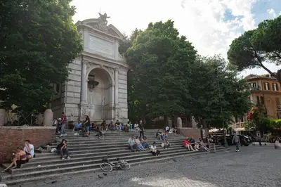 a group of people sitting on steps in front of a building at Trastevere Rooftop Terrace Courtyard Loft in Rome