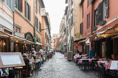 a group of people sitting at tables in an alley at Trastevere Rooftop Terrace Courtyard Loft in Rome