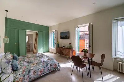 a bedroom with a bed and a table and chairs at Trastevere Rooftop Terrace Courtyard Loft in Rome