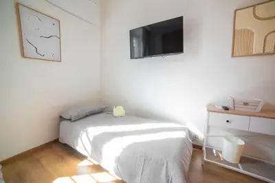 a bedroom with a bed and a tv on the wall at Casa Stefano at the Vatican comfort in the Heart of Rome in Rome