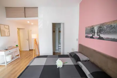 a bedroom with a bed and a pink wall at Casa Stefano at the Vatican comfort in the Heart of Rome in Rome
