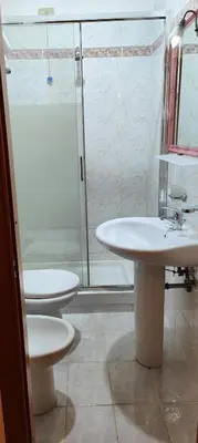 a bathroom with two sinks and a glass shower at House Fenicia in Rome