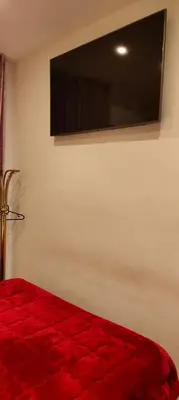 a bedroom with a red bed and a flat screen tv at House Fenicia in Rome