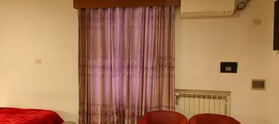 a curtain in a room with a bed and red chairs at House Fenicia in Rome