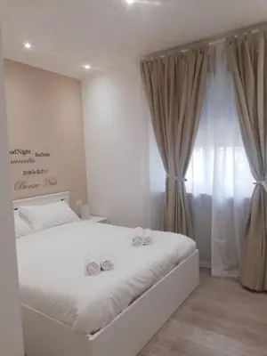 a bedroom with a white bed with two wedding bows at New Jebs sweet home Rome in Rome