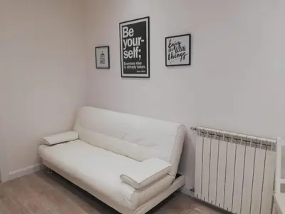 a white couch in a room with a sign on the wall at New Jebs sweet home Rome in Rome