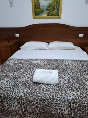 a bed with a leopard print blanket with a towel on it at AFFITTACAMERe ROME PALACE in Rome
