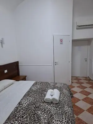 a bedroom with a bed with two slippers on it at AFFITTACAMERe ROME PALACE in Rome