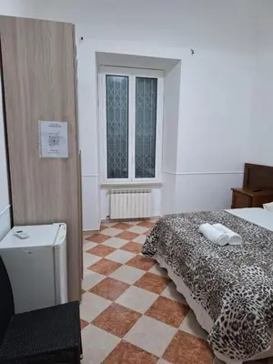 a bedroom with a bed and a checkered floor at AFFITTACAMERe ROME PALACE in Rome