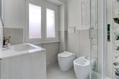 a bathroom with a sink and a toilet and a window at Marconi APT per Famiglie - 20 Min dal centro in Rome