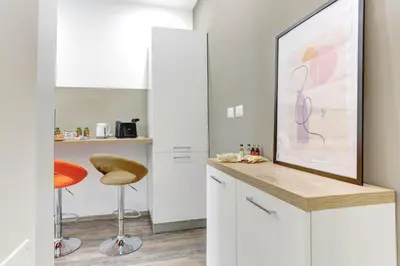 a kitchen with a painting on the wall and a stool at Marconi APT per Famiglie - 20 Min dal centro in Rome