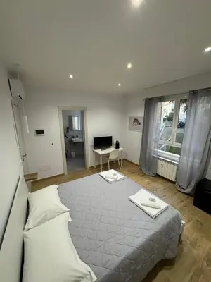 a bedroom with a large bed and a desk at Suite Rooms Garbatella in Rome