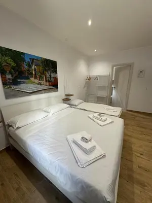 a bedroom with a large white bed with towels on it at Suite Rooms Garbatella in Rome