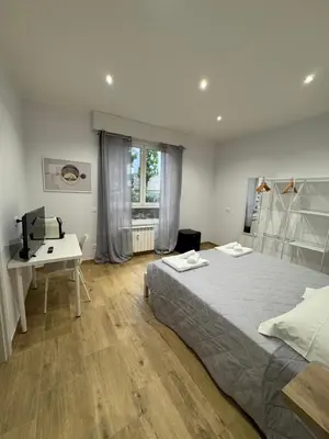 a bedroom with a bed and a desk and a window at Suite Rooms Garbatella in Rome