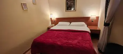 a bedroom with a bed with a red comforter at Soggiorno Fenicia in Rome