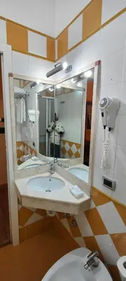 a person taking a picture of a bathroom mirror at Soggiorno Fenicia in Rome