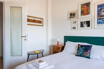 a bedroom with a white bed with a green headboard at Casa Adele Lovely Mid-century Apartment, Rome in Rome
