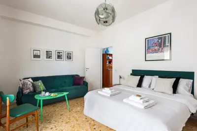 a living room with two beds and a green couch at Casa Adele Lovely Mid-century Apartment, Rome in Rome