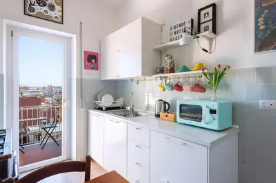 a kitchen with white cabinets and a microwave at Casa Adele Lovely Mid-century Apartment, Rome in Rome