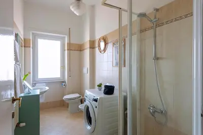 a bathroom with a shower and a washing machine at Casa Adele Lovely Mid-century Apartment, Rome in Rome