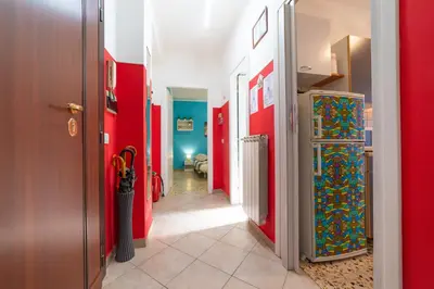 a hallway with a refrigerator in a room with red walls at Lemon House in Rome