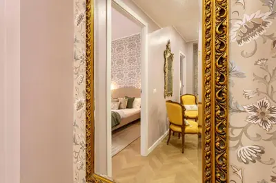 a large gold mirror in a room with a bedroom at Amelie - Gem of Trastevere in Rome