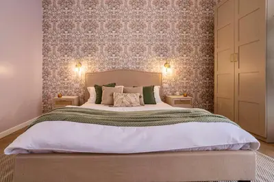 a bedroom with a large bed with floral wallpaper at Amelie - Gem of Trastevere in Rome