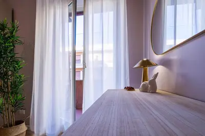 a bedroom with a table with a lamp and a mirror at Amelie - Gem of Trastevere in Rome
