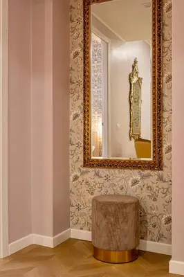 a mirror on a wall with a stool in a room at Amelie - Gem of Trastevere in Rome