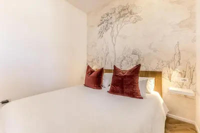 a bedroom with a white bed with two pillows at Domvs Romana in Rome