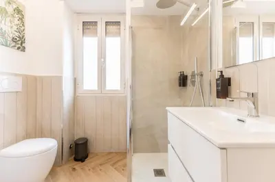 a white bathroom with a toilet and a sink at Domvs Romana in Rome