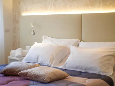 a bed with white pillows on top of it at Vatican Views Elegant Spacious e Unforgettable in Rome