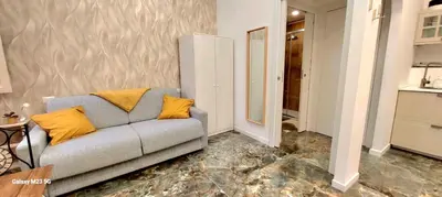 a living room with a gray couch with yellow pillows at Rome Center Bello Loft in Rome
