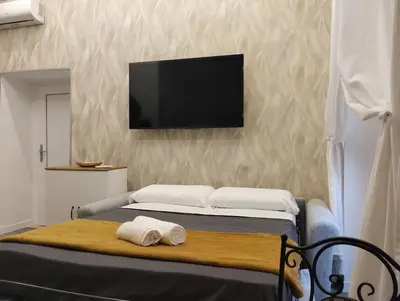 a bedroom with a bed with a tv on the wall at Rome Center Bello Loft in Rome