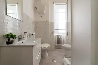 a white bathroom with a toilet and a sink at Domvs Tibvrtina - Solarium Zone, Terrace, A-C, Roma in Rome